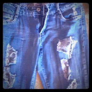 Ripped jeans with gray fabric behind rips
